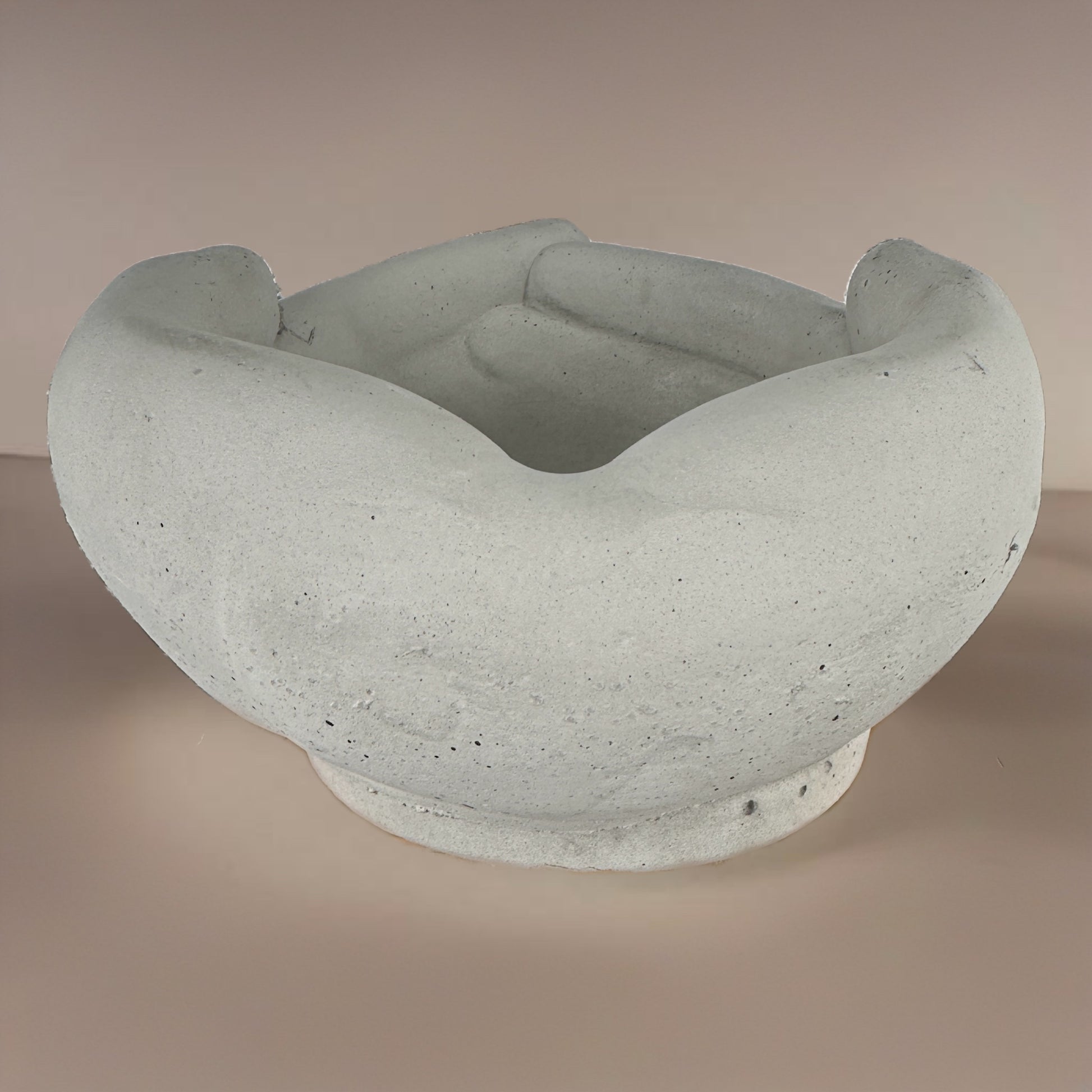 Back angle of a concrete pot shaped like interlocked hands, showing the smooth rear curvature and joined fingertips design